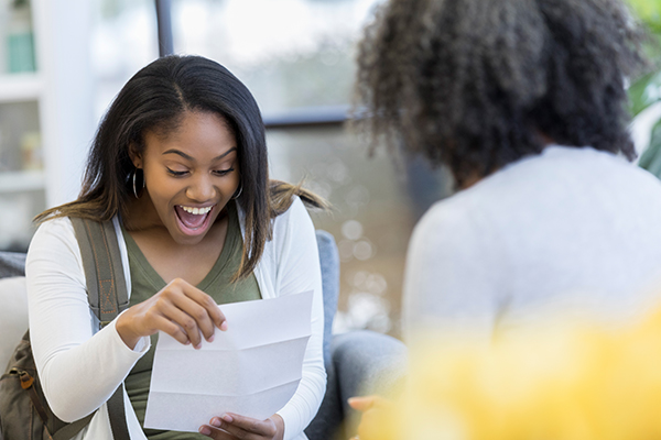 A woman smiles in reaction to receiving a financial aid package